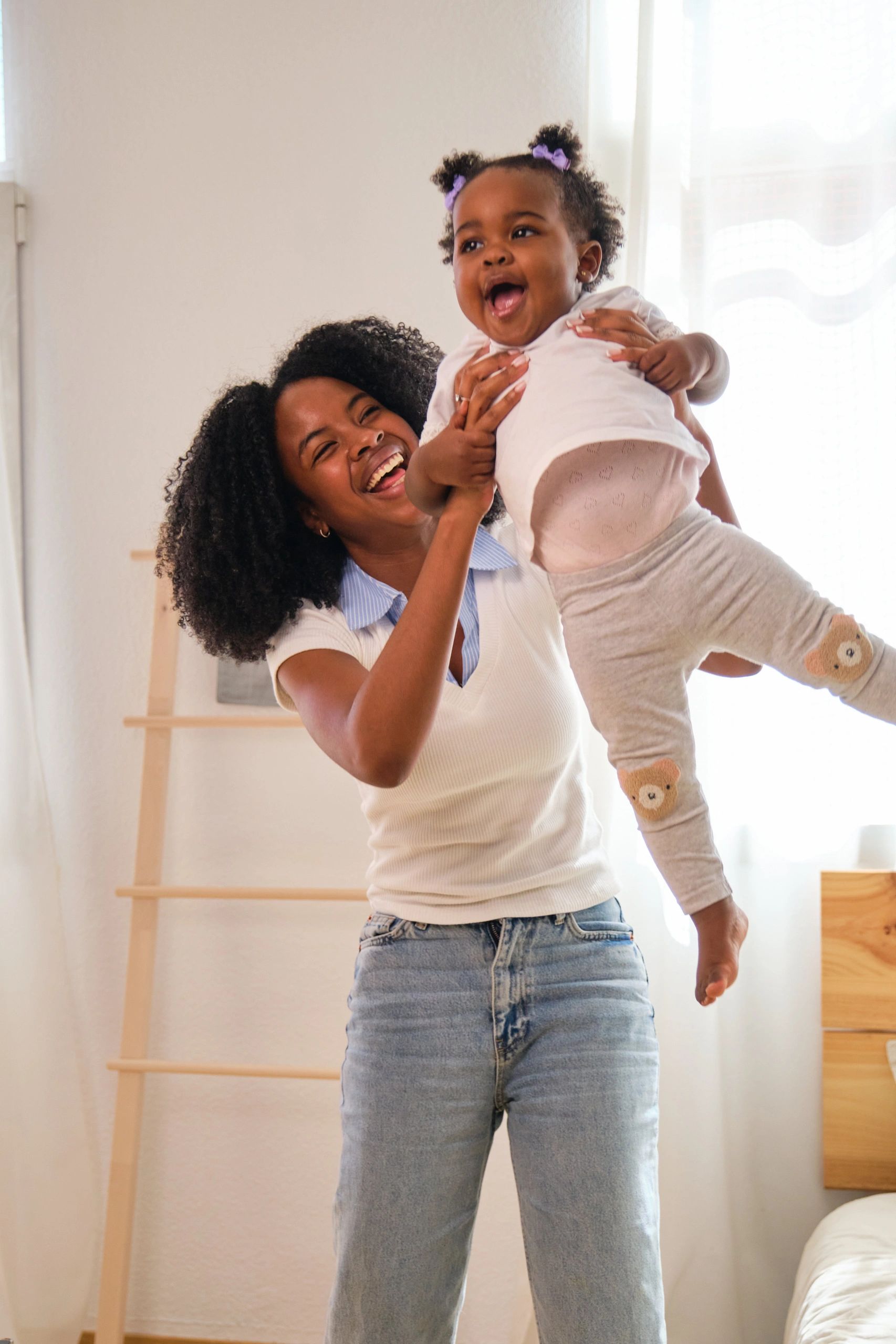 Mother joyfully playing with her baby