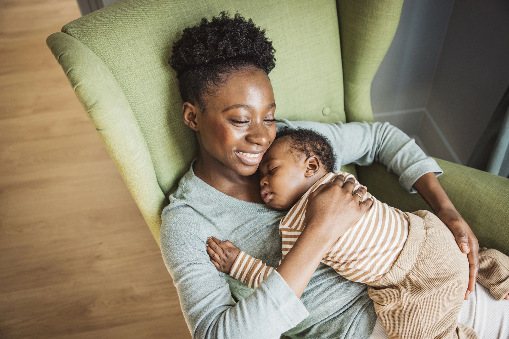 Mother holding sleeping baby at home