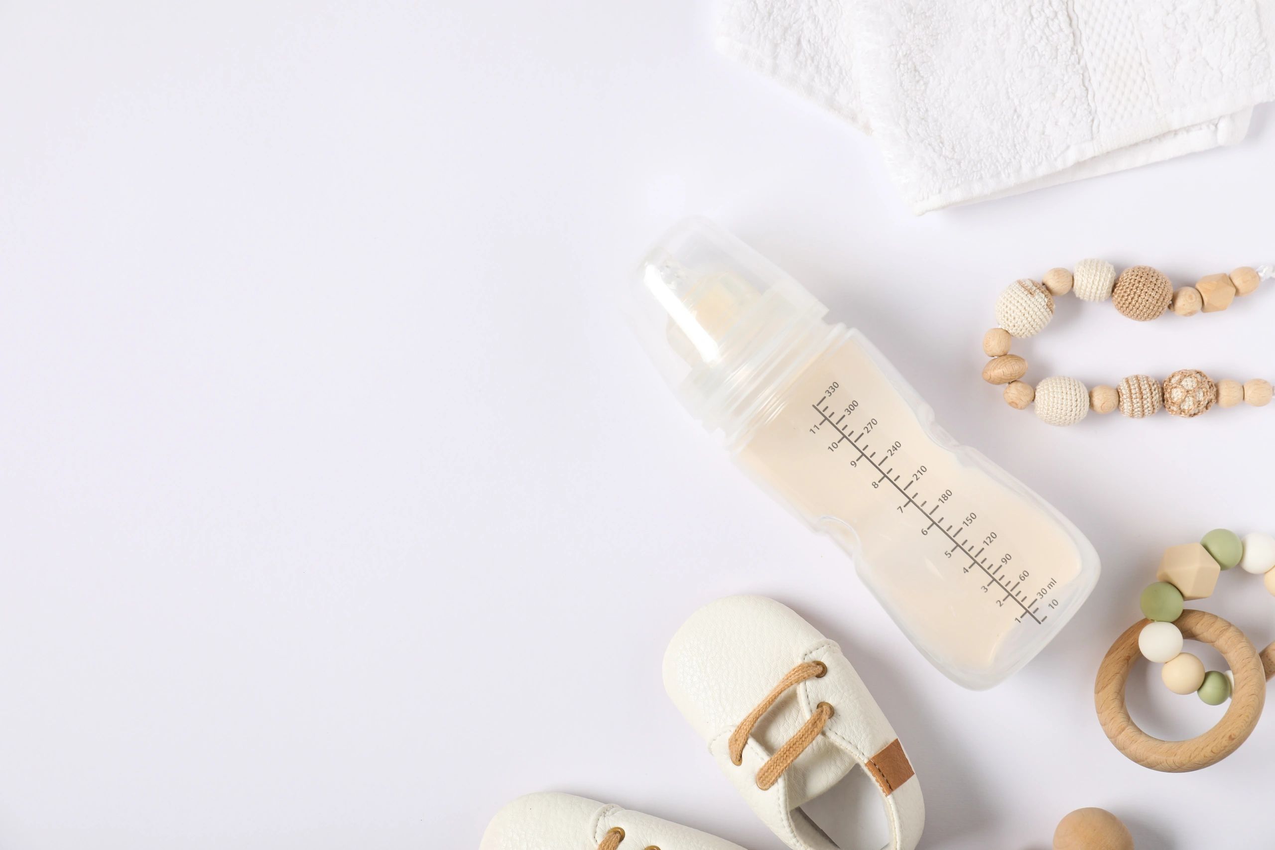 Baby feeding essentials arranged on a light background